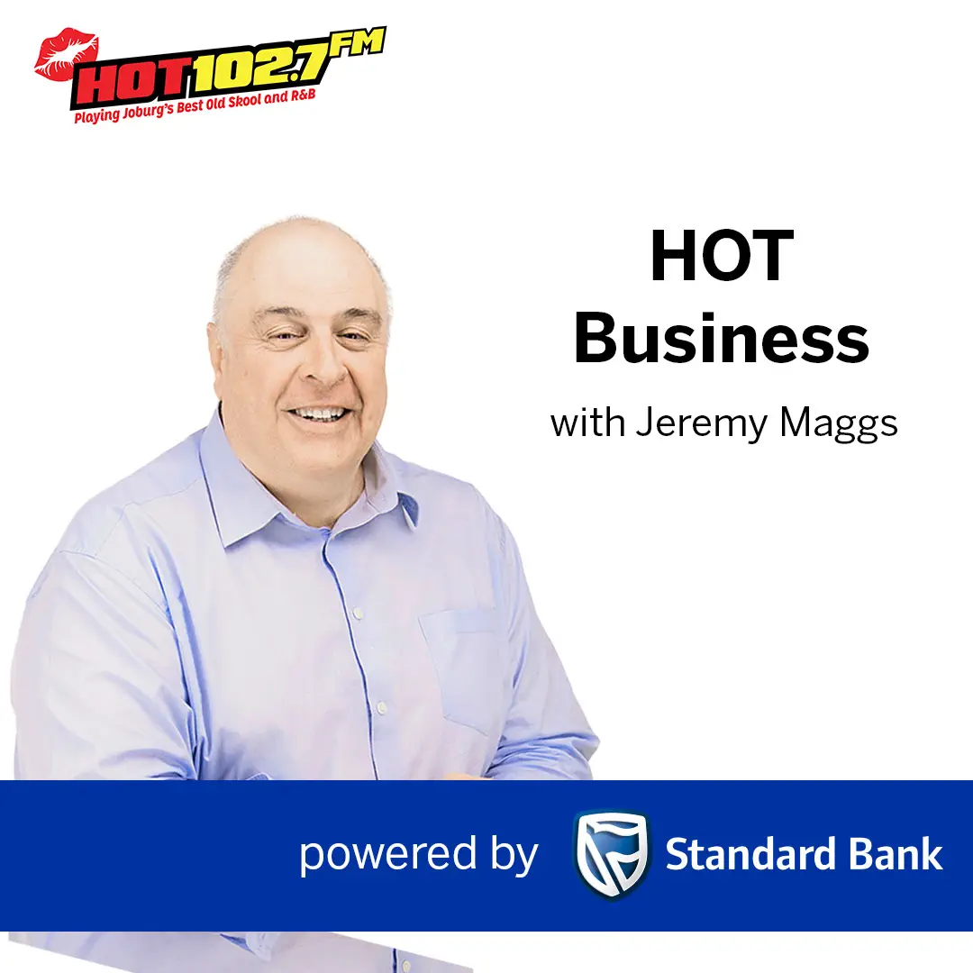 A man in a light purple shirt smiles at the camera. Text reads HOT Business with Jeremy Maggs and powered by Standard Bank. The Hot Business logo for HOT 102.7 FM radio appears in the top left corner.